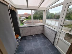 a bathroom with two windows and a tiled floor at Beautiful apartment met zicht Damse vaart @brugge in Bruges