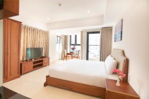 sypialnia z dużym łóżkiem i telewizorem w obiekcie Bao Son Hotel - Apartment w mieście Nha Trang