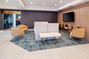 a lobby with a waiting room with a tv and chairs at Holiday Inn Express Hollywood Walk of Fame by IHG in Los Angeles