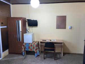 a room with a desk with a chair and a television at Royal German Guest House in Ablekuma