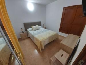 ein kleines Schlafzimmer mit einem Bett und einem Holzschrank in der Unterkunft La casita de Candida in Tigaday