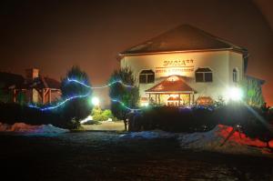 Uma casa com luzes de Natal à frente. em Imola Motel em Gheorgheni