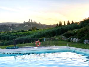 una piscina in un campo con una collina sullo sfondo di Casa SaMa a San Gimignano