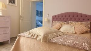 a bedroom with a bed with a pink headboard at CasAlbina in Mezzana