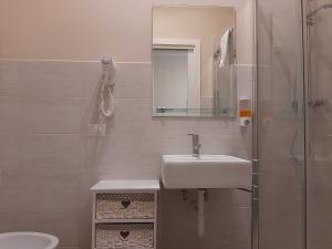 a bathroom with a sink, mirror, and toilet at Affittacamere Stazione Empoli in Empoli