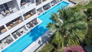 an overhead view of a hotel with a swimming pool and a palm tree at Lardos Bay Hotel in Lartos