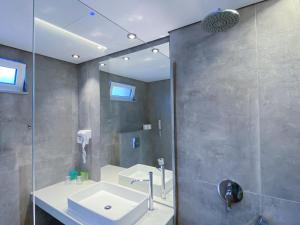a bathroom with a shower, sink, and mirror at Lardos Bay in Lartos