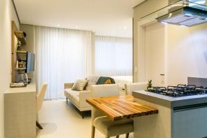 a kitchen and living room with a table and a stove at Pool | Food hall | 450m from the mall #CA03 in Florianópolis +34 photos