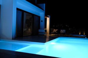 una piscina con iluminación azul en un edificio en The Bower Sivota Bay, en Sivota