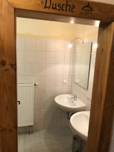 ein weißes Badezimmer mit einem Waschbecken und einem Spiegel in der Unterkunft Heuhof-Breitau Heulager in Sontra