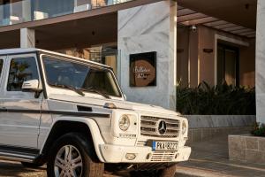 a white jeep parked in front of a building at Bellevue On The Beach Suites in Rhodes Town