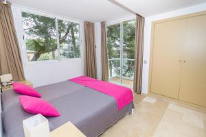 
a bedroom with a large bed and a large window at Eix Platja Daurada Hotel & SPA in Can Picafort
