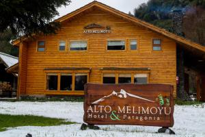 a log building with a sign in front of it at Alto Melimoyu Hotel & Patagonia in La Junta