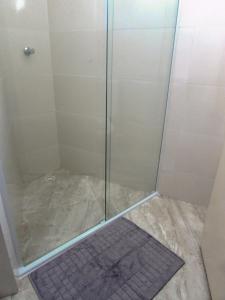 eine Dusche mit Glastür und einem Teppich in der Unterkunft Hotel Minho - Ótima Escolha Próximo à 25 de Março, Brás, Bom Retiro e Metrô - Café da Manhã Incluso - Estacionamento em Frente in São Paulo + 48 Fotos