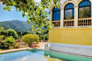 a house with a swimming pool and a balcony at B&B Can Casadella in Premia de Dalt