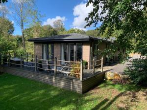 eine kleine Hütte mit einer Terrasse im Gras in der Unterkunft Chycara in Truro