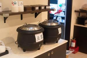 two large pots sitting on a shelf in a kitchen at Discovery Motel - Yanping in Taipei