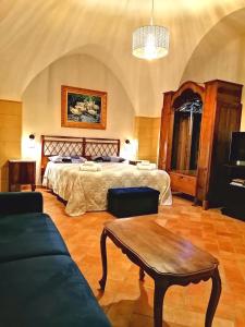 a bedroom with a bed and a table and a couch at San Michele delle grotte BnB in Gravina in Puglia