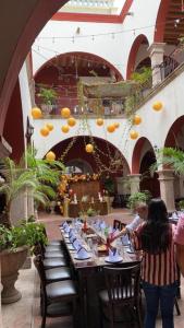 a long table in a restaurant with oranges on the ceiling at Hotel Santa Elena in El Fuerte