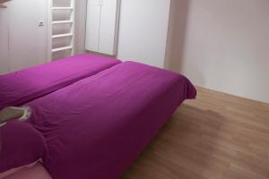 a purple bed in a room with a ladder at Appartement Zuidstraat Domburg in Domburg