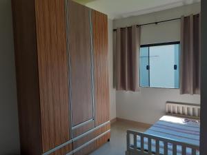 ein kleines Schlafzimmer mit einem Bett und einem Fenster in der Unterkunft Suítes Queen Central in Uberaba