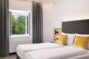 Postel nebo postele na pokoji v ubytování Stadthotel Oberndorf - 24h Self Check-In Terminal
