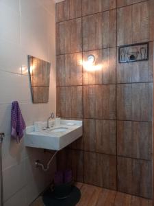 uma casa de banho com um lavatório e uma parede de madeira em Recanto Pousada Sonho Meu em Analândia