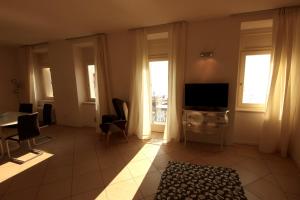 a living room with a television and a table and chairs at Hotel San Marco in Malcesine