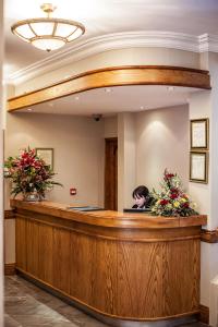 a woman sitting at a reception desk in a waiting room at Gullane's Hotel in Ballinasloe