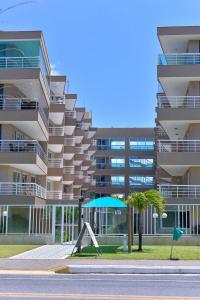 un edificio con un paraguas azul delante de él en Beach Place Cumbuco, en Cumbuco