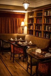 a restaurant with tables and chairs in a library at Gullane's Hotel in Ballinasloe