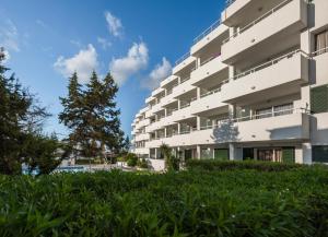 a large white building with a tree in front of it at Camelina Suites in San Antonio Bay