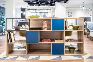 a wooden book shelf with blue boxes at Holiday Inn London Kensington High St. by IHG in London +139 photos