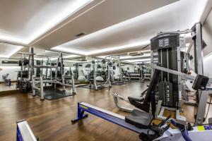 a gym with several treadmills and machines at Holiday Inn London Kensington High St., an IHG Hotel in London
