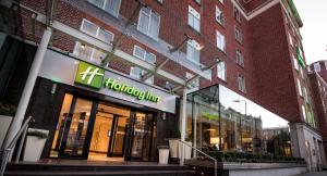 a store front of a brick building with a sign on it at Holiday Inn London Kensington High St. by IHG in London