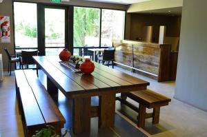 a dining room with a wooden table and benches at Terra Malal in Chos Malal