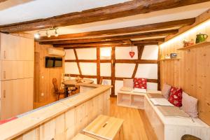 a living room with wooden walls and a room with a table at Schriner Hüss - Chambres d'hôtes & Gîtes in Beblenheim