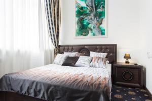 a bedroom with a bed and a painting on the wall at Sumskaya Apartment Lux in Kharkiv
