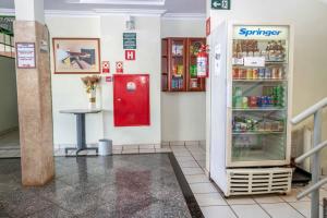 a store with a red refrigerator and a table at Hotel Portucali in Ribeirão Preto