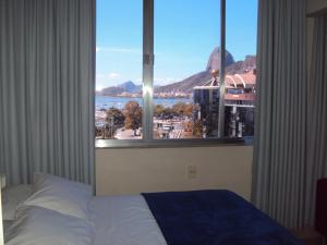 1 dormitorio con cama y ventana grande con vistas en Apartamento Botafogo Beach, en Río de Janeiro