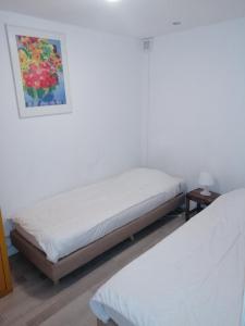 two beds in a room with a painting on the wall at Apartment StayWell Amsterdam Free Parking in Amsterdam