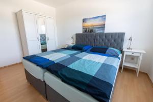 - une chambre avec un lit et une couette bleue et blanche dans l'établissement Ferienwohnung Garten, à Unterneukirchen