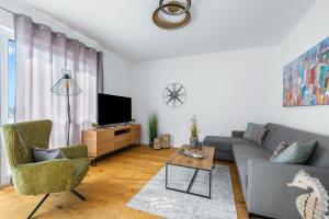 a living room with a couch and a tv at Sounds of the Sea in Olpenitz