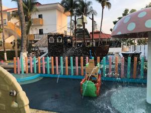 een waterglijbaan in een zwembad met een piratenschip bij Hotel Villa Murano in Puerto Arista