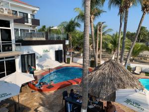 a beach area with a pool, chairs, and a tent at Hotel Villa Murano in Puerto Arista