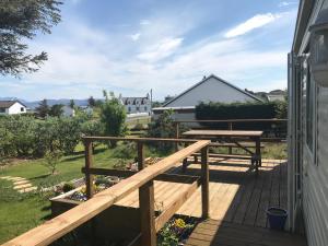 a wooden deck with a bench and a picnic table at Croft No 6 in Orbost