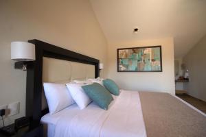 a bedroom with a large white bed with blue pillows at Hotel Villa Murano in San Cristóbal de Las Casas +91 photos