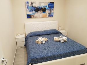 een slaapkamer met een bed met 2 paar slippers bij La Casa Di Francesco (Trilocale Arredato) in Canicattì