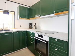 una cocina verde con encimeras blancas y armarios verdes en 6 person holiday home in Hadsund en Hadsund
