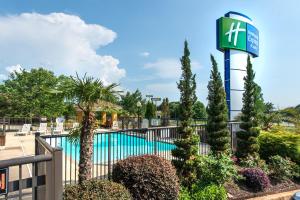 una piscina en un complejo con un cartel y plantas en Holiday Inn Express Hotel & Suites Anderson I-85 - HWY 76, Exit 19B, an IHG Hotel, en Anderson